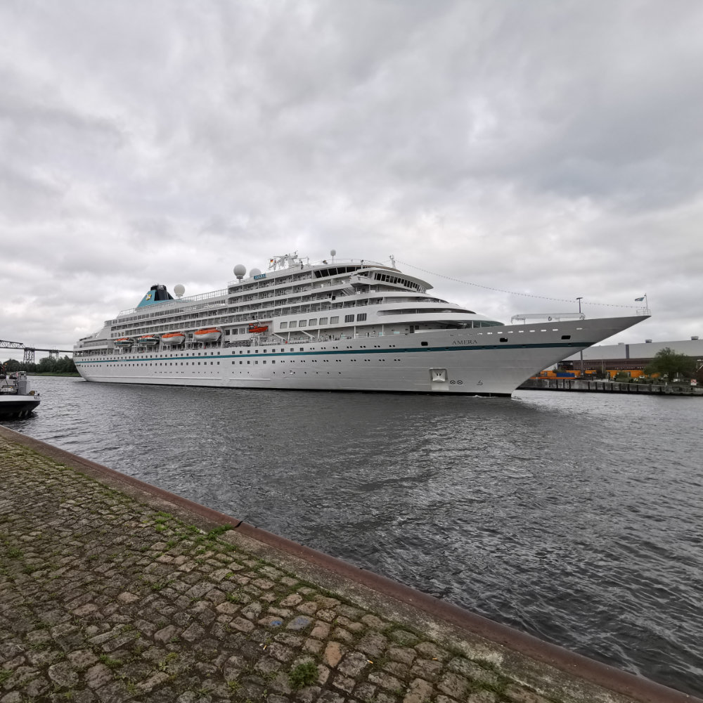 young man side profile having beard trimmed with scissors