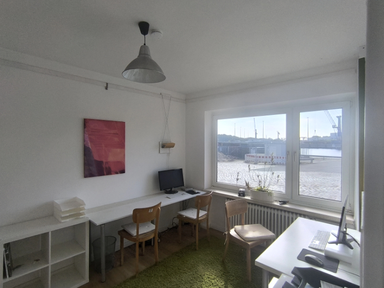 barber using styling spray on young man with black hair, short on sides and long in a quiff on top